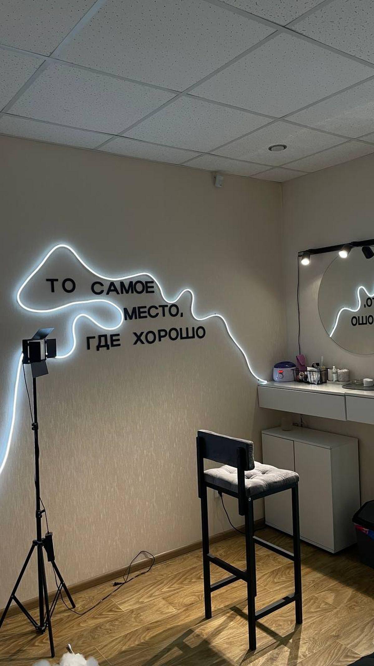 Интерьер студии красоты «Дело в любви» в Краснообске: неоновая надпись «То самое место, где хорошо» и гримёрная зона